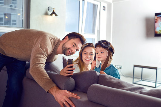 A happy family makes selfie at the phone in the room.