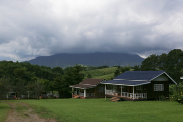 Landscape mountain view before the storm with cottage house in countryside.