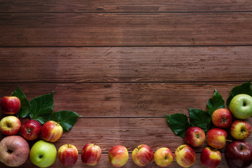 Apples on the wooden table arranged in the form of picture frame with copyspace