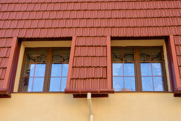 modern wooden Dormer Windows in the red tiled roof, the tide matched the color of the roof, gutters to match the wall