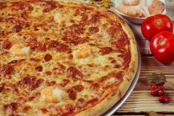 6732115 Delicious seafood italian pizza served on wooden table.