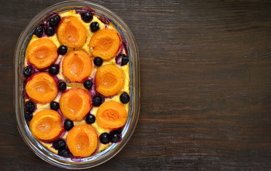Cottage cheese casserole with apricots and black currant, top view, copy space