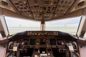 Airplane is parking at Beijing airport after completed work of pilot crews in the morning. Inside cockpit can see all flight instruments of the airplane.