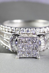 A diamond engagement ring in a box with glint/reflection. Shimmering princess-cut diamonds.