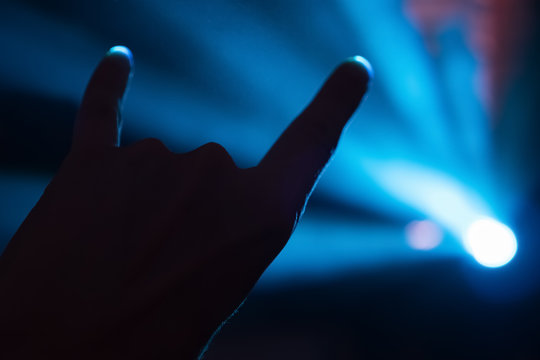 Rock-n-roll salute. Gesture backround. Concert concept. Music lights