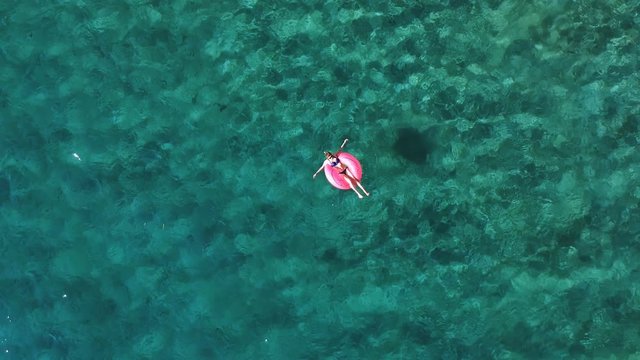 Aerial view of woman enjoy sea and sun on floatie