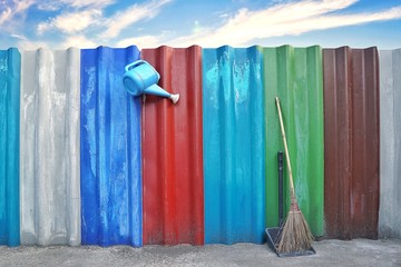 Broom stick and cleaning supplies equipment on the floor at outdoor on colourful wall and blue sky background.Inspired to doing household chore.People,Housework, cleaning and housekeeping concept. 
