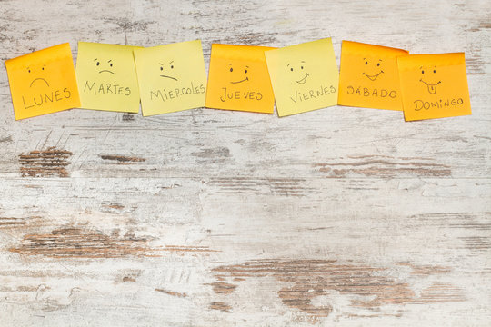 Post it pegatinas con d&iacute;as de la semana y caras  sobre fondo de madera r&uacute;stico. Vista superior. Copy space