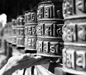 Buddhist prayer wheels and a hand