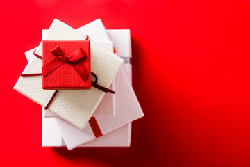 White and red gift boxes on red background. Top view. Copyspace