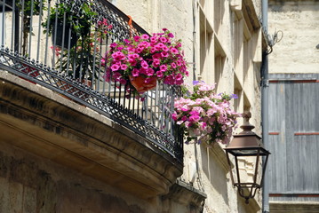 Fototapeta na wymiar Ville de Pézenas, balcon fleuri en fer forgé et vieille lanterne, département de l'Hérault, France