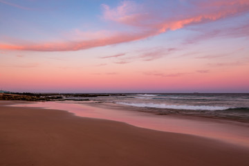 Sunset clouds illuminated in pink at the beach.