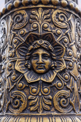 Fototapeta na wymiar Old metal pillar with human face