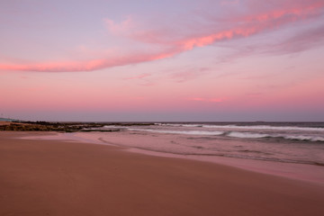 Fototapeta na wymiar Sunset clouds illuminated in pink at the beach.