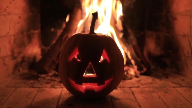 Halloween pumpkin with scary face on fire background.