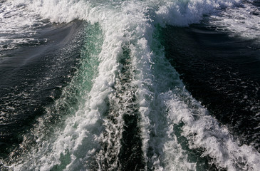 The wake from a power boat going at full speed through the water.