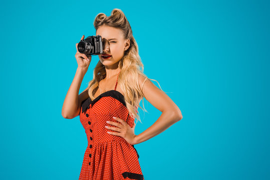beautiful woman in retro dress with photo camera isolated on blue