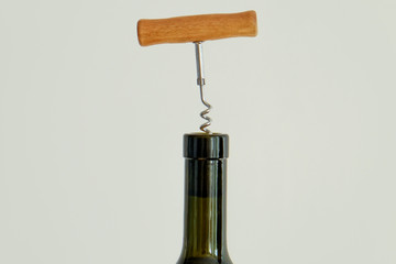 Cropped shot of green glass bottle of wine bottleneck, cork & corkscrew on white isolated...