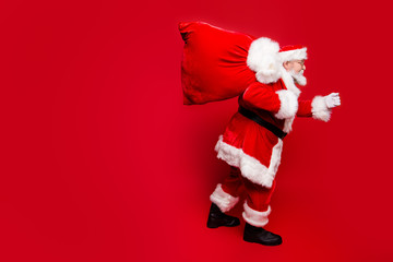 Profile side view of Santa in eyeglasses gloves outfit in hurry 