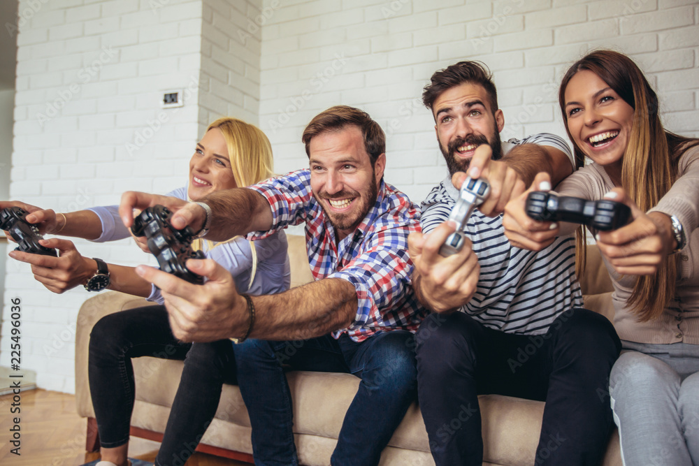 Wall mural Group of friends play video games together.