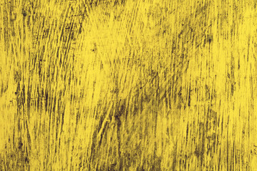 A wooden wall is covered with bright rich old paint. Old yellow wood background texture
