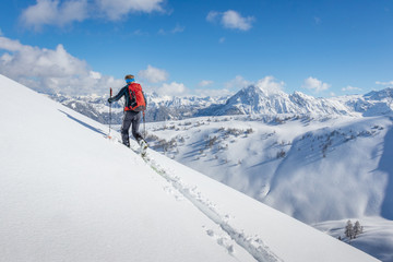 Fototapeta na wymiar Male ski tourer walking up a summit in the alps