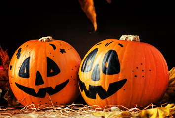 Composition festive d& 39 Halloween avec des gardes de citrouilles souriants, lanterne, paille et feuilles tombées sur fond de bois foncé, style rustique, mise au point sélective