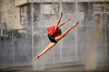 Beautiful young gymnast jumping high up. Flying