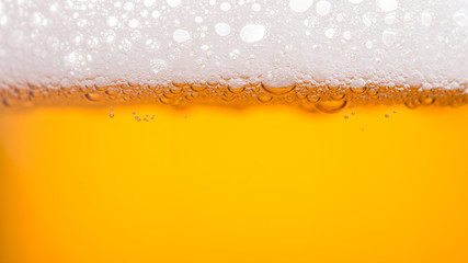 Pouring beer with bubble froth in glass for background. Summer drink, October fest texture