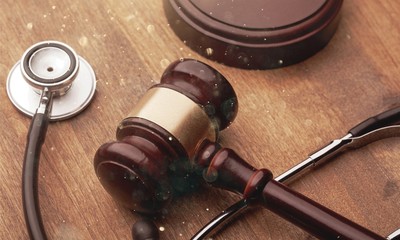 Gavel and stethoscope on wooden background