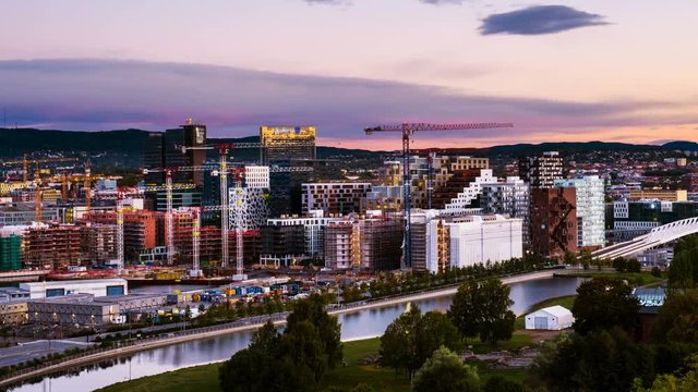 Oslo, Norway. A sunrise view of Sentrum area of Oslo, Norway, with Barcode buildings and the river Akerselva. Construction site with sunrise colorful sky. Time-lapse, zoom in