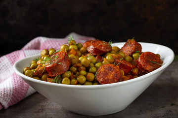 Stew made from green peas, carrot and pork sausages