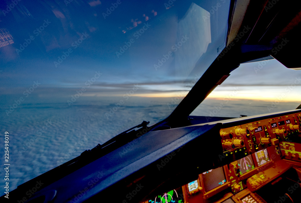 Wall mural the view from commercial airplane, seen from captain seat in cockpit in the evening twilight during 