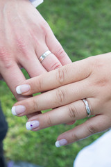 wedding engagement rings on the finger of the bride and groom