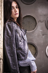 Lovely young hipster model posing in the street in front of a trendy gate. Beauty and fashion composition.