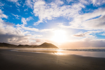 Fototapeta premium The beautiful Wharariki Beach with famous rocks. Sunset scene golden light and silhouette. Nelson, South Island, New Zealand.