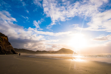 Fototapeta na wymiar The beautiful Wharariki Beach with famous rocks. Sunset scene golden light and silhouette. Nelson, South Island, New Zealand.