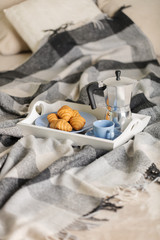Breakfast in bed. On a white tray there is a coffee maker, coffee blue cup and croissants.