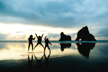 A group of people taking a photo with with famous rocks. Sunset scene golden light and silhouette....