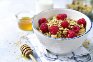 Homemade multicereal granola with fresh raspberry, honey and dairy product.