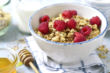 Homemade multicereal granola with fresh raspberry, honey and dairy product.
