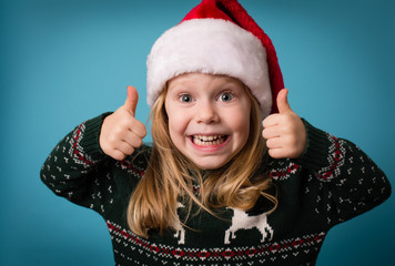 Happy Little Christmas Girl Giving Thumbs Up, Isolated on Teal