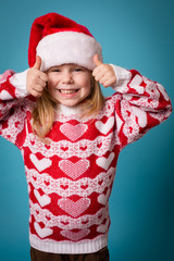 Happy Little Christmas Girl Giving Thumbs Up, Isolated on Teal