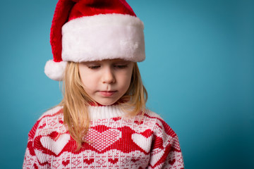 Sad Little Christmas Girl in Santa Hat, Isolated on Teal