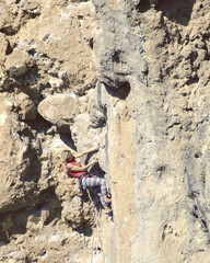 Young female rock climber on a cliff face.