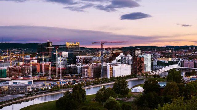 Oslo, Norway. A sunrise view of Sentrum area of Oslo, Norway, with Barcode buildings and the river Akerselva. Construction site with sunrise colorful sky. Time-lapse