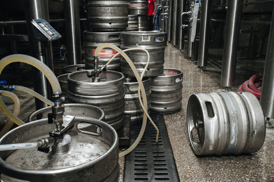Steel industrial stack of beer kegs against.