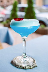 Blue cocktail standing on the table on bar's terrace outdoor 