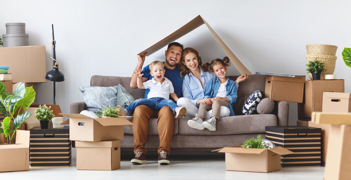 Happy Family Mother Father And Children Move To New Apartment And Unpack Boxes