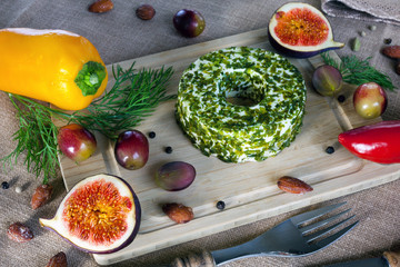 Fototapeta na wymiar Soft cheese with herbs on a wooden Board surrounded by spices, vegetables and fruits